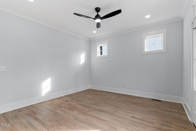 empty room featuring ornamental molding, a ceiling fan, recessed lighting, light wood-style floors, and baseboards