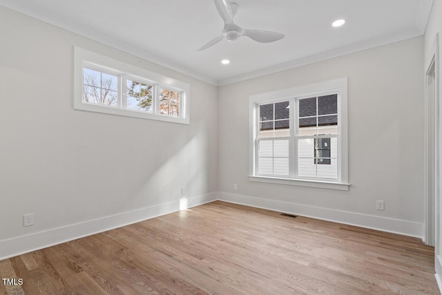 empty room featuring visible vents, wood finished floors, and baseboards