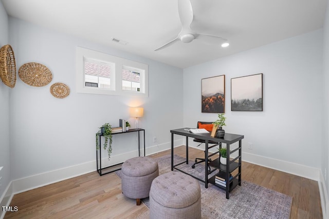 office featuring baseboards, ceiling fan, wood finished floors, and visible vents