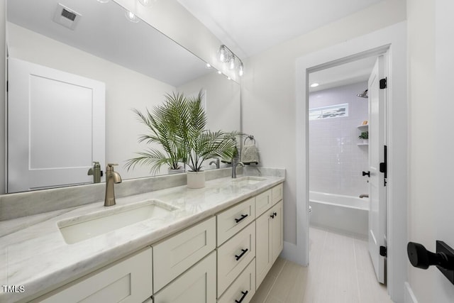 bathroom with a sink, shower / bathtub combination, double vanity, and visible vents