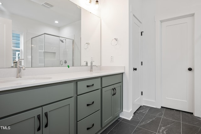 full bathroom with double vanity, a stall shower, marble finish floor, and a sink