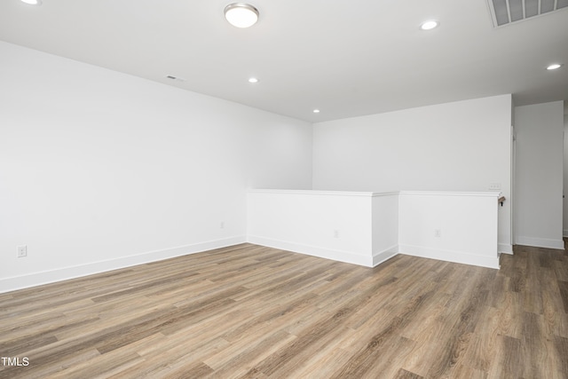 unfurnished room featuring baseboards, wood finished floors, visible vents, and recessed lighting