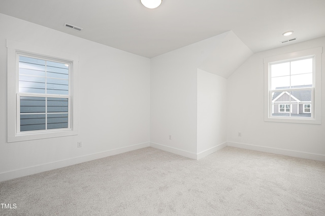 bonus room with carpet floors, lofted ceiling, visible vents, and baseboards