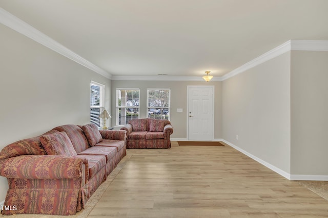 living room featuring ornamental molding, baseboards, and light wood finished floors