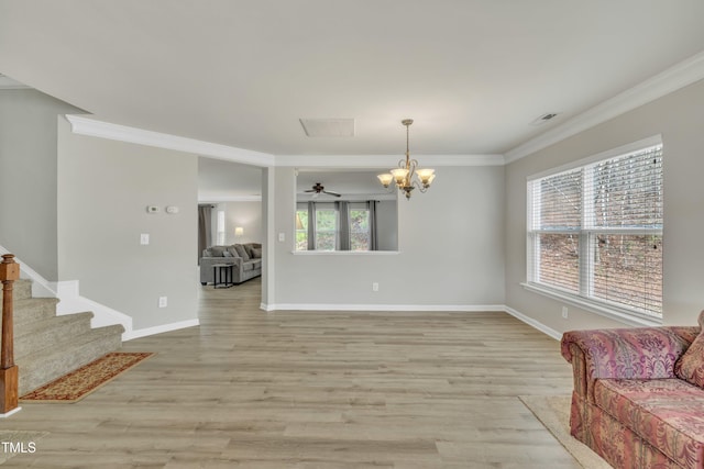 living room featuring a wealth of natural light, visible vents, light wood-style floors, and crown molding