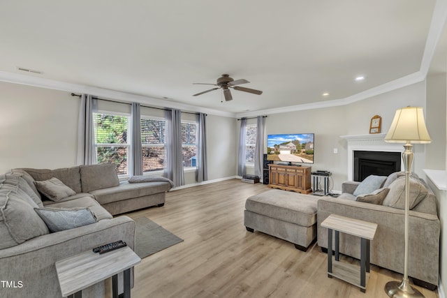 living area featuring light wood-type flooring, a fireplace, crown molding, and baseboards