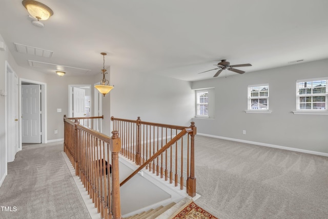 corridor featuring light carpet, visible vents, and an upstairs landing