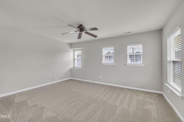 unfurnished room with ceiling fan, carpet flooring, visible vents, and baseboards