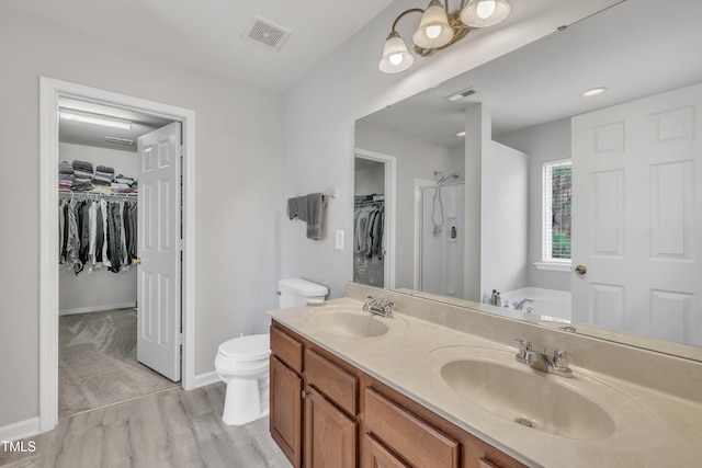 bathroom with a bath, toilet, a sink, and visible vents