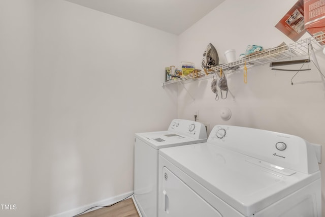 laundry room featuring laundry area, light wood-style floors, washing machine and dryer, and baseboards