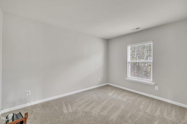 spare room featuring baseboards, visible vents, and carpet flooring