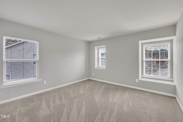 spare room featuring carpet and baseboards