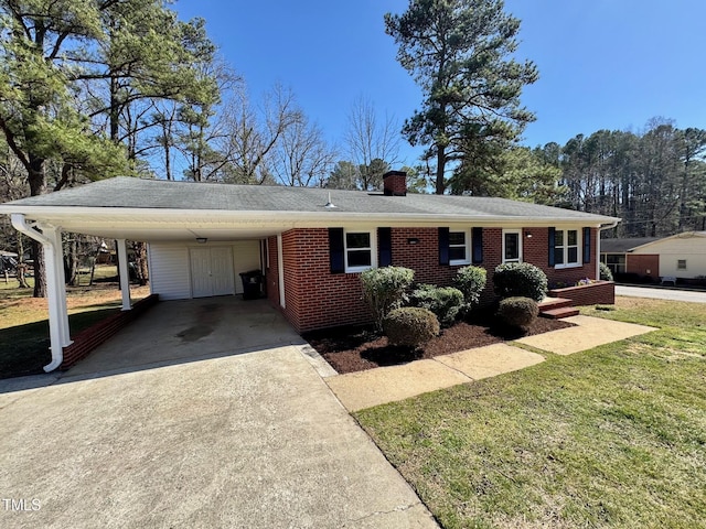 ranch-style home with brick siding, a front lawn, concrete driveway, a chimney, and a carport