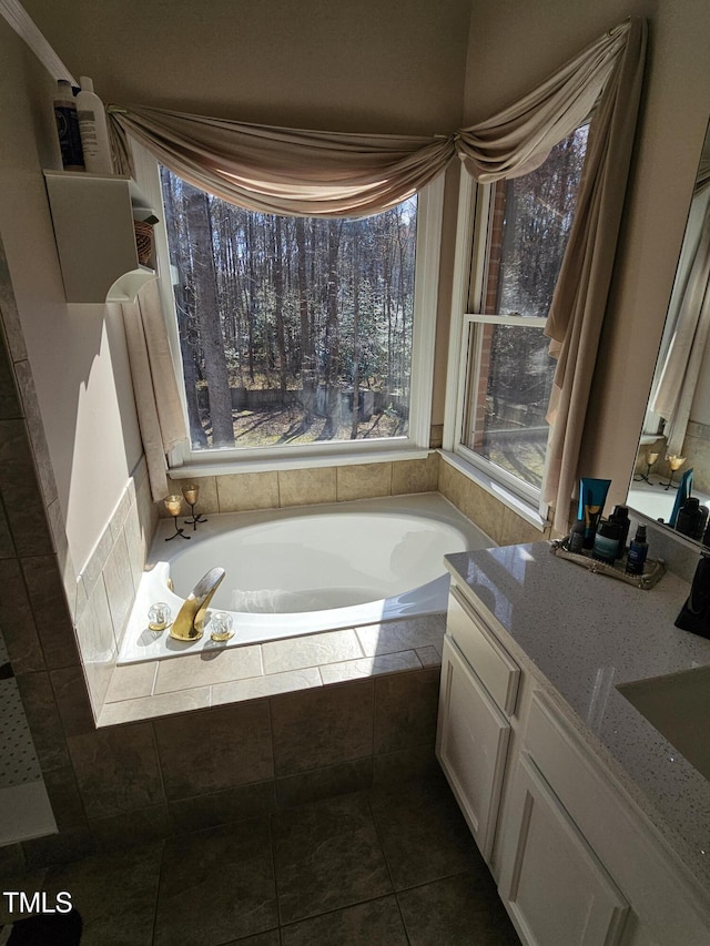 bathroom with a bath, vanity, and tile patterned flooring