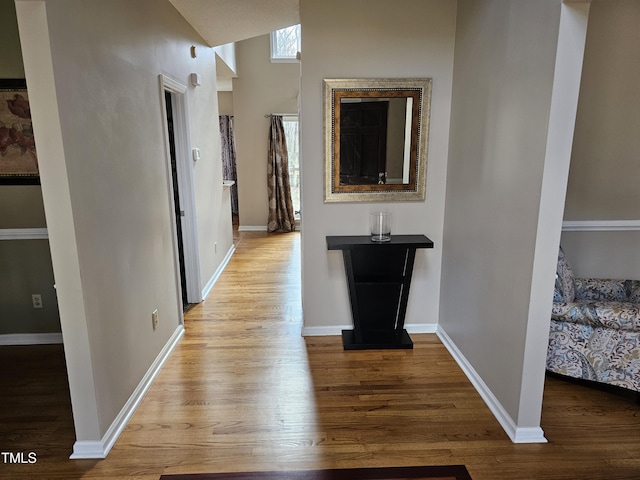 corridor with wood finished floors and baseboards