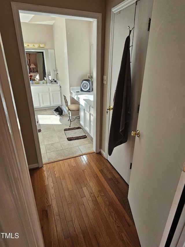 hall featuring light wood-style floors and baseboards