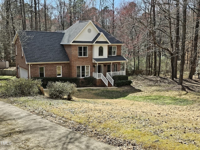 view of front facade featuring brick siding, covered porch, and an attached garage