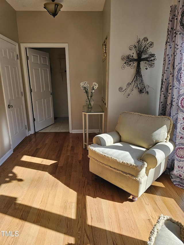 sitting room featuring baseboards and wood finished floors