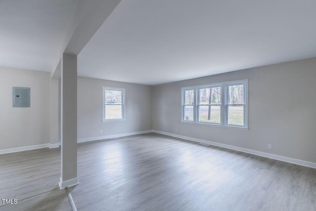 interior space featuring electric panel, baseboards, and wood finished floors