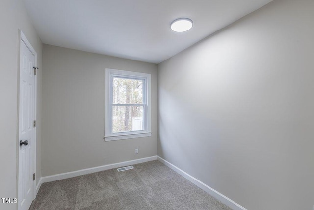 carpeted spare room with visible vents and baseboards