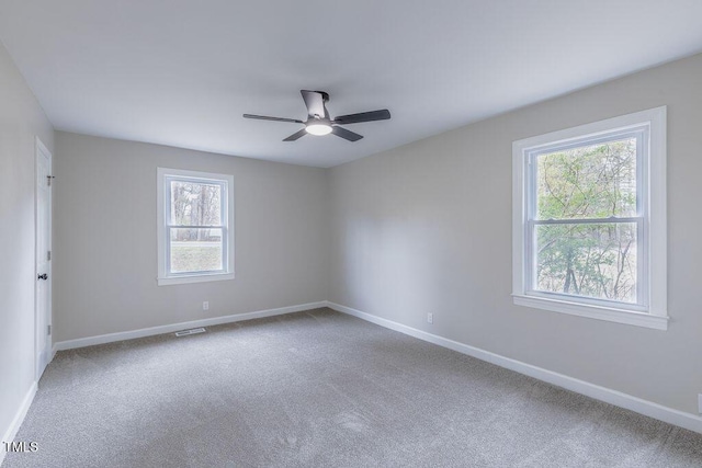 spare room with ceiling fan, carpet, visible vents, and baseboards