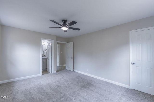 unfurnished bedroom featuring light carpet, ensuite bath, and baseboards