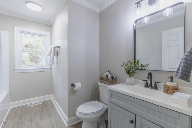 bathroom featuring toilet, wood finished floors, visible vents, baseboards, and ornamental molding