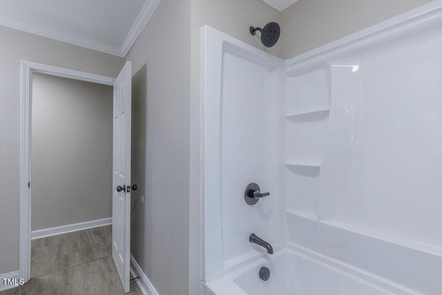 full bathroom with shower / washtub combination, ornamental molding, baseboards, and wood finished floors