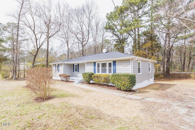 view of front of property featuring crawl space, roof with shingles, a chimney, and a front lawn