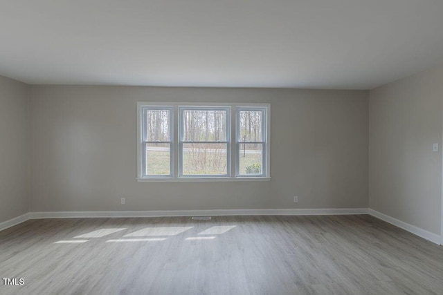 unfurnished room featuring baseboards and wood finished floors