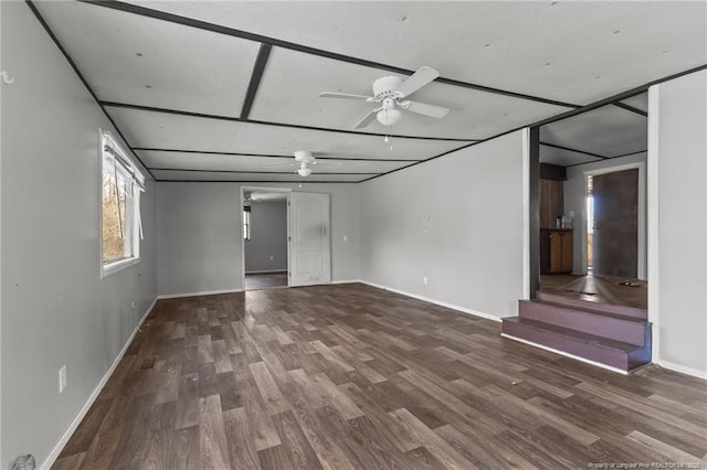 unfurnished living room with ceiling fan, baseboards, and wood finished floors