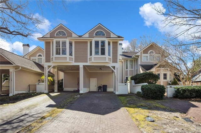 view of front of property featuring driveway, fence, and a carport