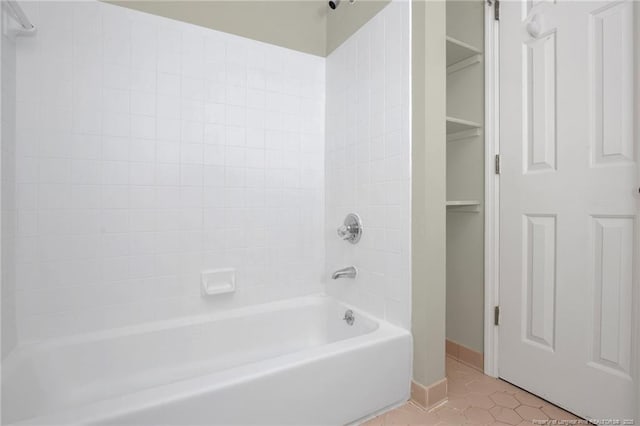 bathroom featuring baseboards, bathtub / shower combination, and tile patterned floors