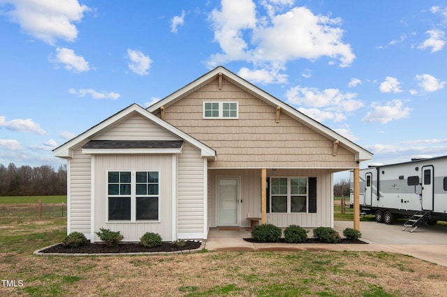 view of front of home featuring covered porch, a front lawn, board and batten siding, and concrete driveway