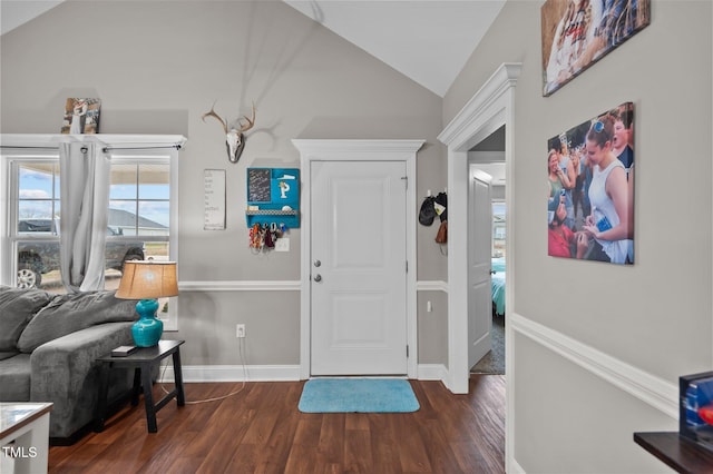 foyer featuring dark wood-type flooring, lofted ceiling, and baseboards