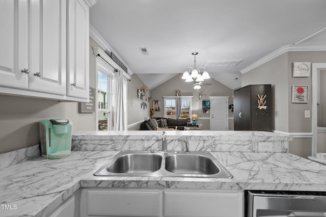 kitchen with a sink, white cabinets, light countertops, an inviting chandelier, and crown molding