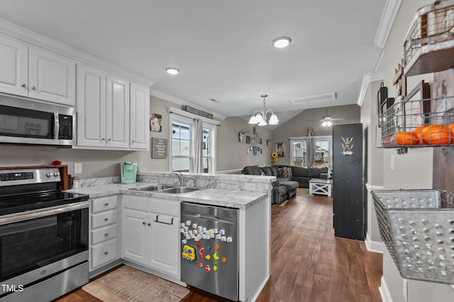 kitchen featuring white cabinets, ornamental molding, open floor plan, stainless steel appliances, and a sink