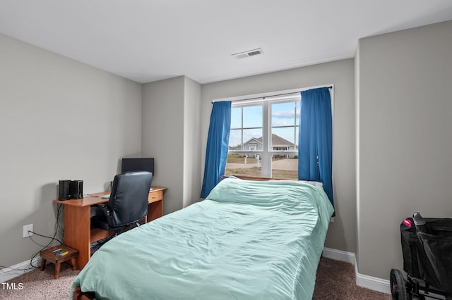 carpeted bedroom featuring baseboards and visible vents