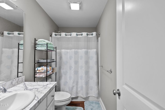 bathroom featuring wood finished floors, shower / tub combo, vanity, and toilet