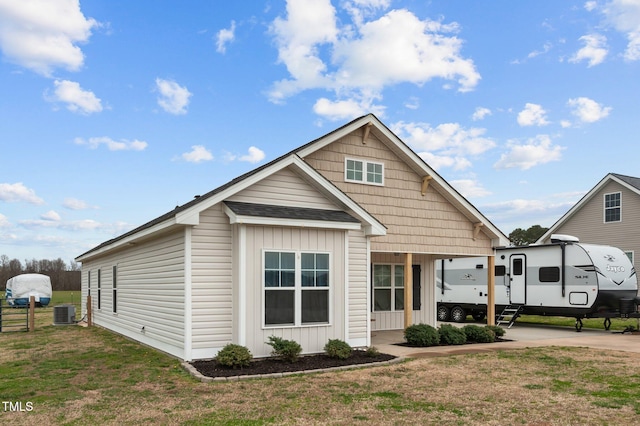 view of front of property with a front lawn and central AC unit