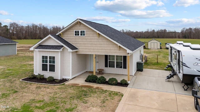 view of front of house featuring a shingled roof and a front yard