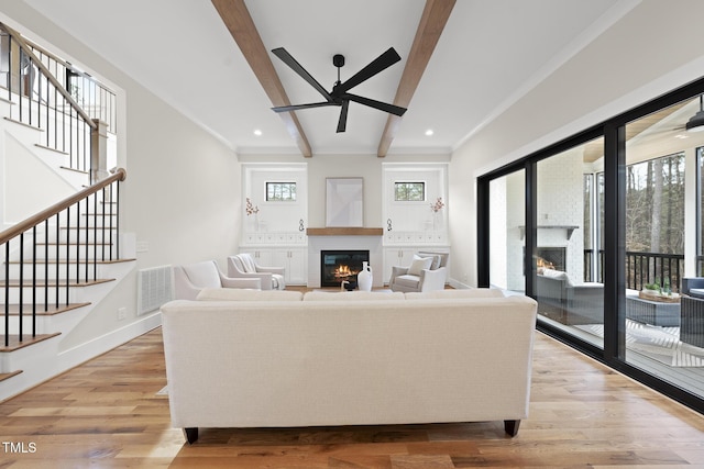 living area featuring a glass covered fireplace, visible vents, and a healthy amount of sunlight