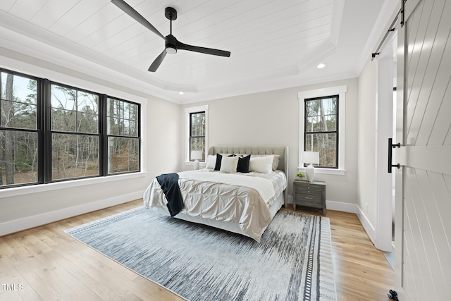 bedroom with baseboards, a raised ceiling, ceiling fan, light wood-type flooring, and recessed lighting