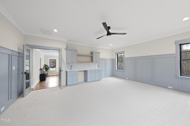 living room with light carpet, built in desk, and a healthy amount of sunlight