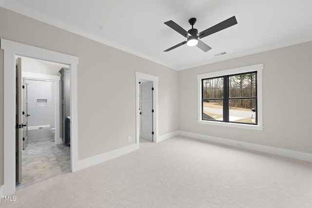 unfurnished bedroom featuring crown molding, visible vents, ensuite bathroom, light carpet, and baseboards