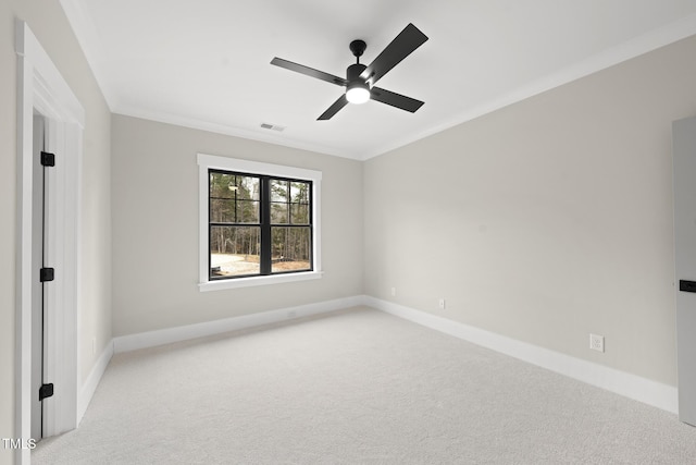 spare room featuring baseboards, visible vents, a ceiling fan, light colored carpet, and crown molding