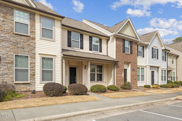 townhome / multi-family property featuring stone siding and brick siding