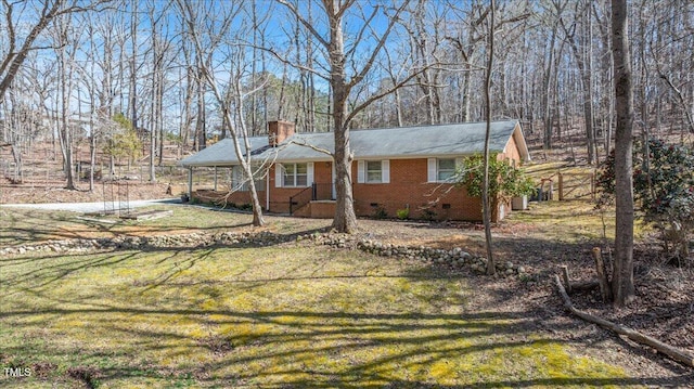 view of front of home featuring a chimney, a lawn, brick siding, and crawl space