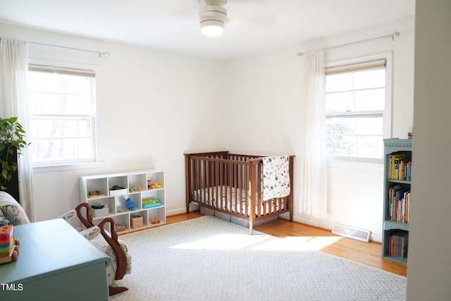 bedroom featuring multiple windows, wood finished floors, and visible vents