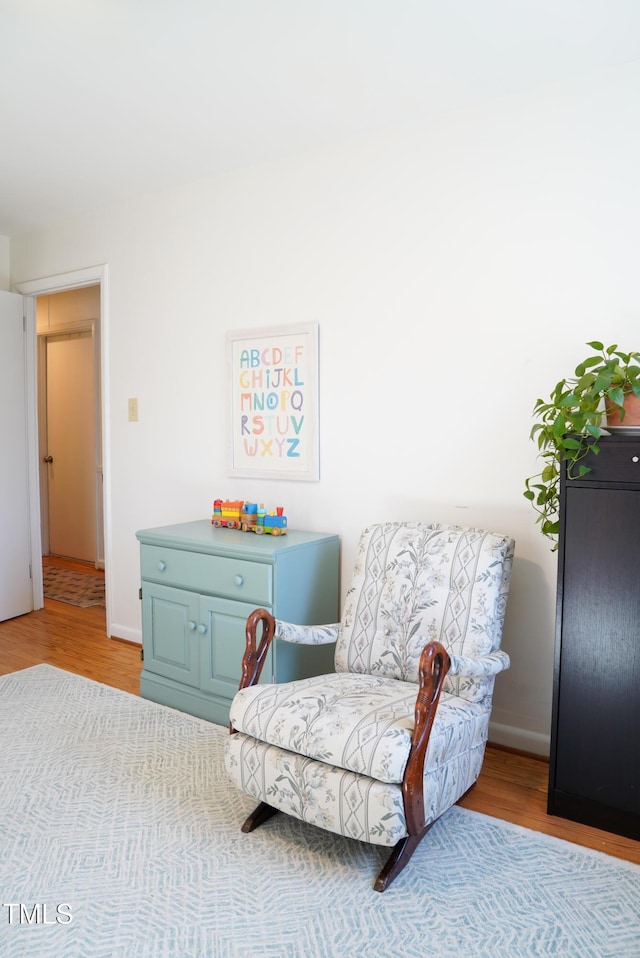 sitting room with baseboards and wood finished floors